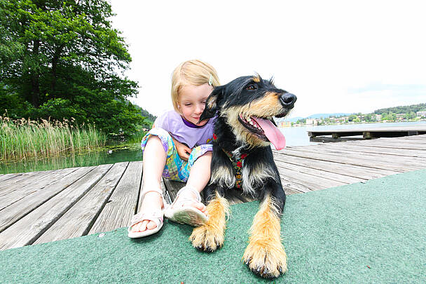 Beste Freunde – Mädchen mit Hund am Badesteg