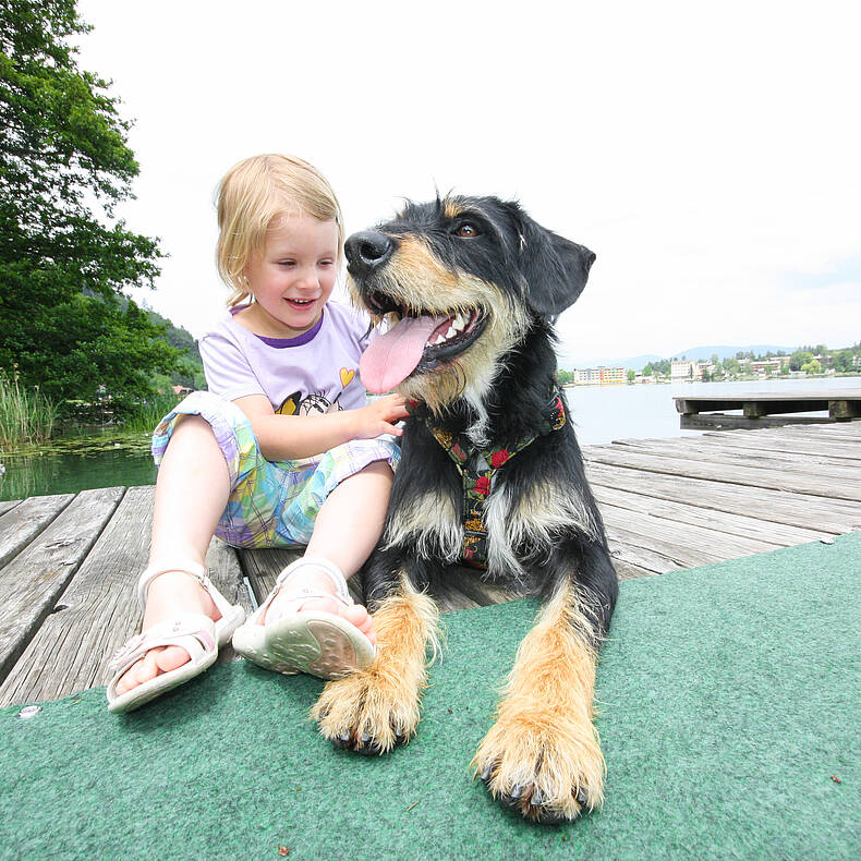 Kind mit Hund am See