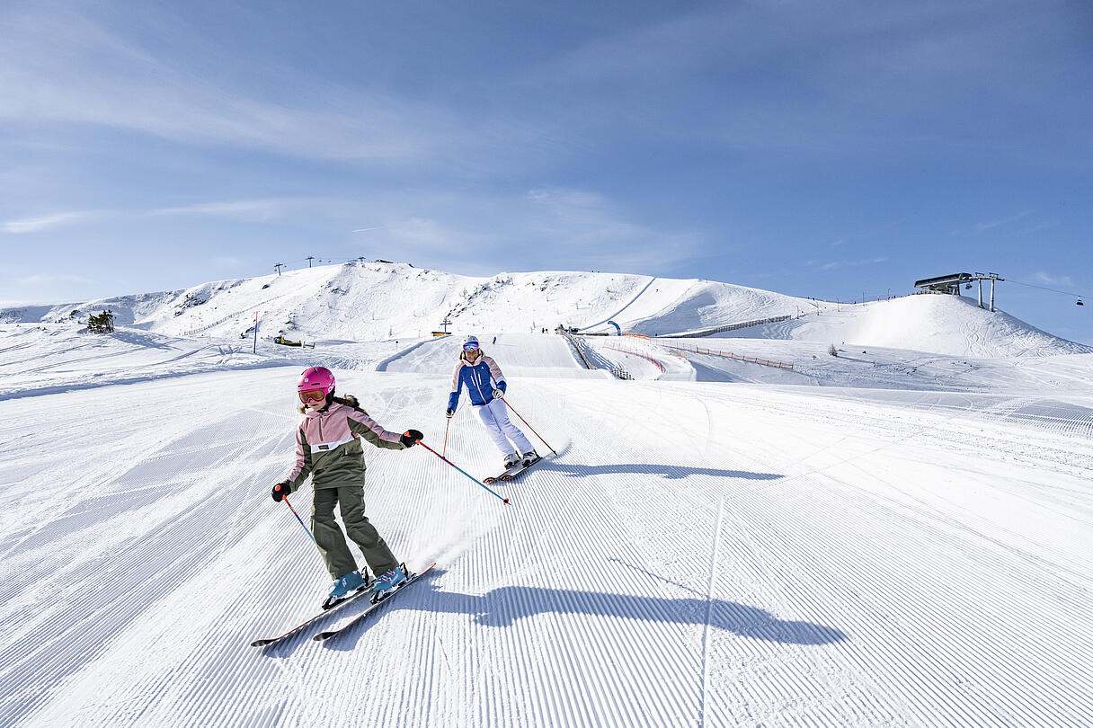 Mama mit Tochter beim Skifahren auf der Turracher Hoehe in den Nockbergen